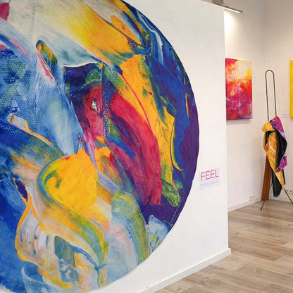 Galerie K49 Ausstellung FEEL mit Wandteppich DSCHUNGLE, rund abstraktes Kunstwerk im Vordergrund, im Hintergrund ein abstraktes Bild und 2 Art-Decken der Künstlerin Regine Rauin